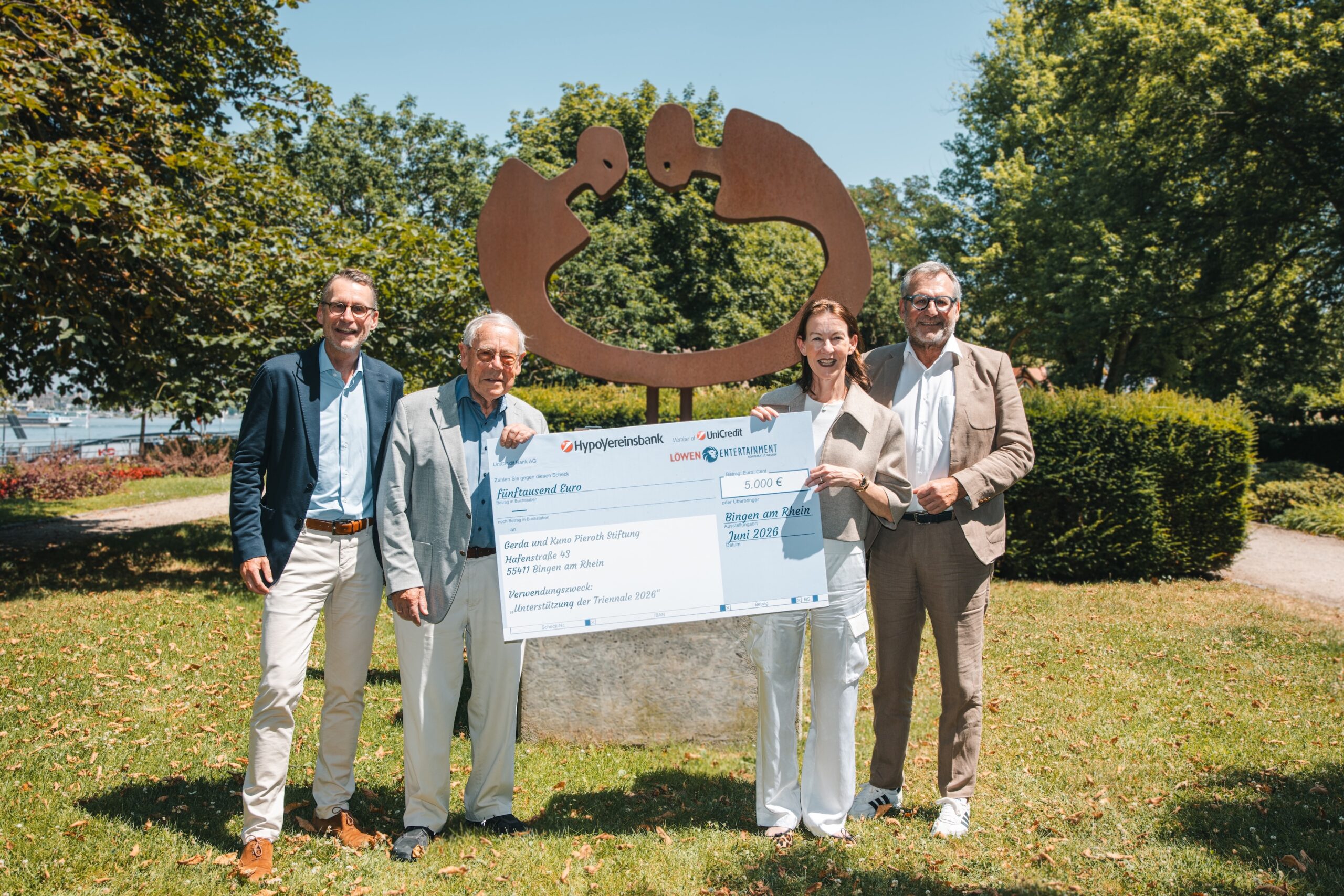 Christian Arras (Löwen Entertainment), Kuno Pieroth und Maria Gleichmann-Pieroth (Gerda und Kuno Pieroth Stiftung) und Oberbürgermeister der Stadt Bingen Thomas Feser vor der Skulptur „Verbindung“ von Albrecht Genin am Binger Kulturufer. (Foto: Alexander Stoll)
